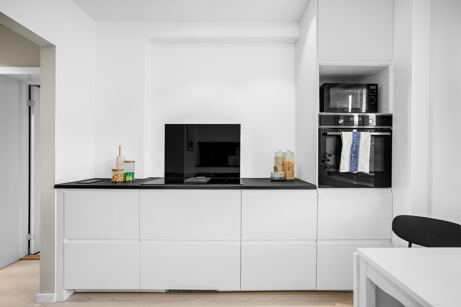 Mørk benkeplate med sort kompositt-vask og ett- greps armatur i sort. Bachsplasch plate i sort glass. Galleribilde