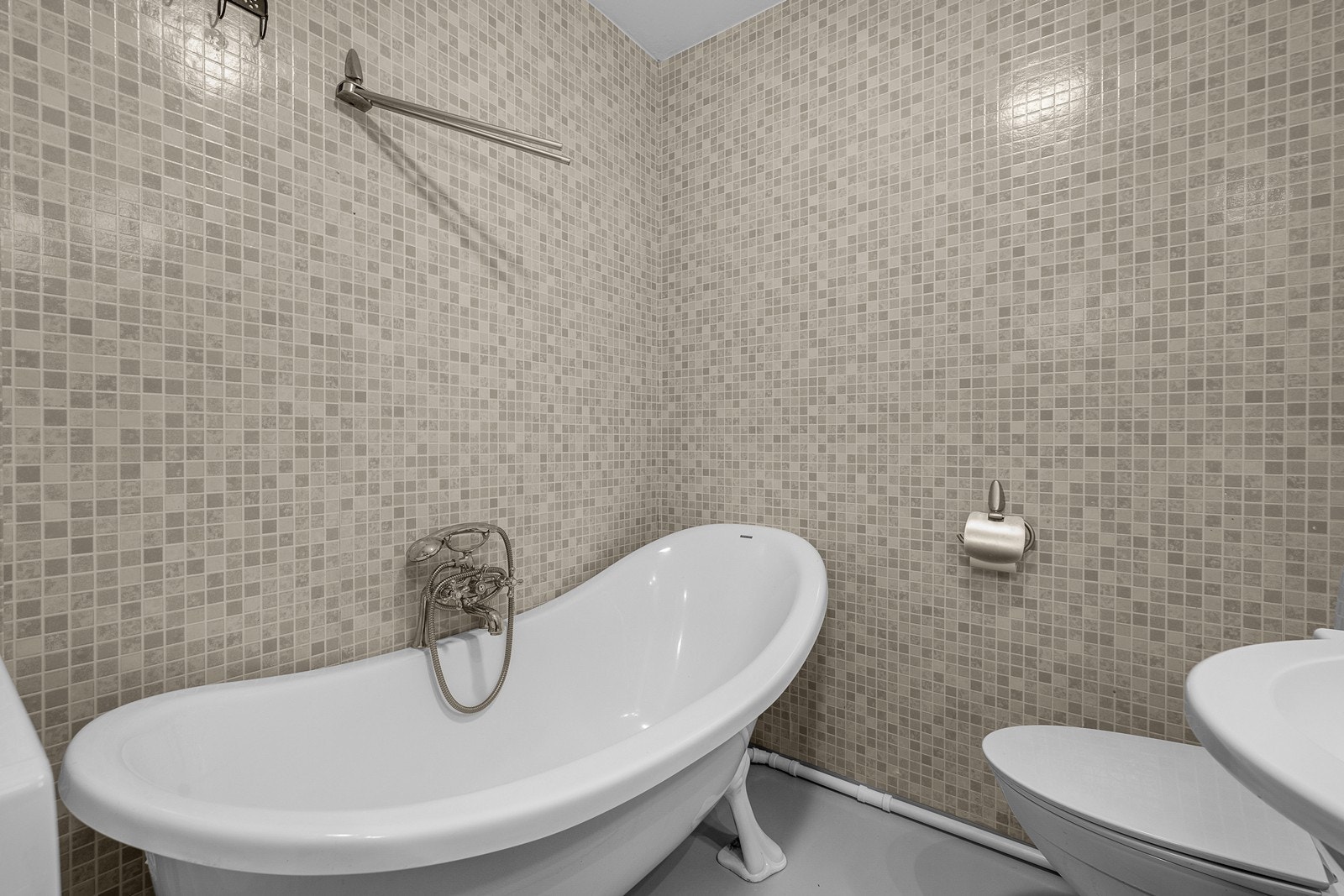 Rommet er innredet med servantskap med 1-greps blandebatteri. badekar, gulvstående toalett og det er opplegg for vaskemaskin! Galleribilde