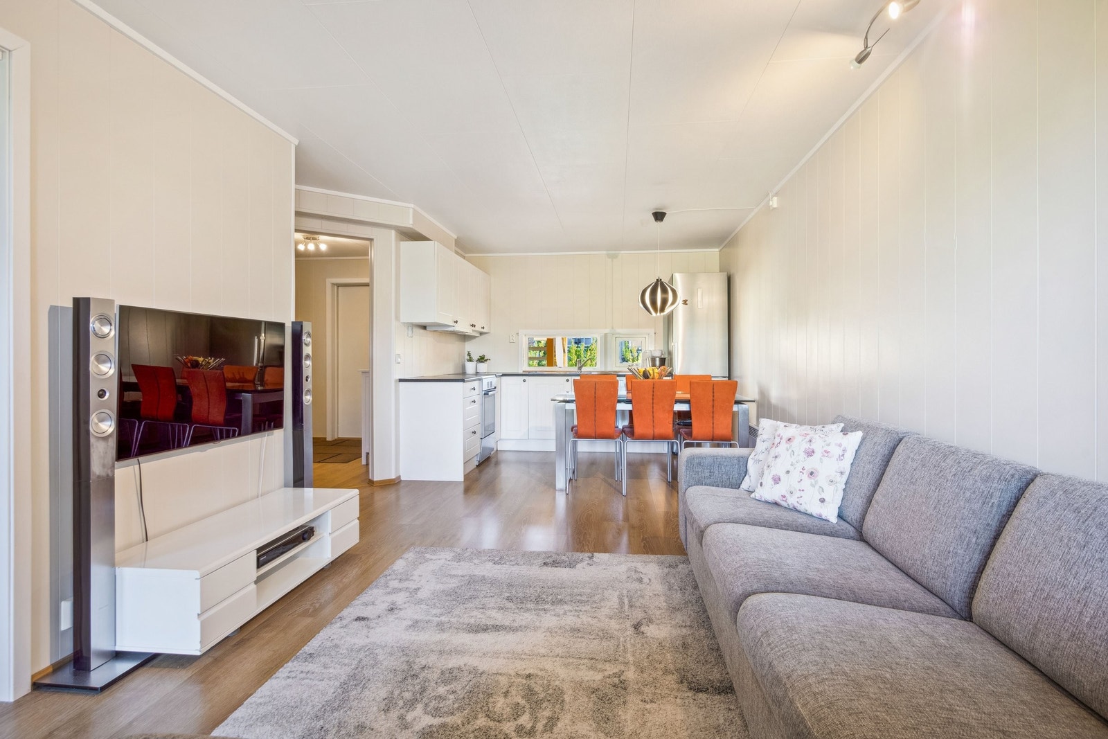 Leiligheten har et lyst og innbydende allrom med stue og kjøkken i åpen løsning Galleribilde