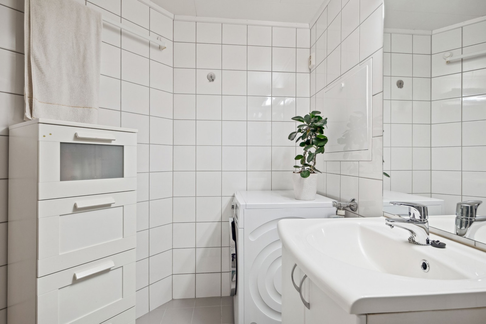 Baderom er innredet med nedfelt servant, opplegg for vaskemaskin Galleribilde