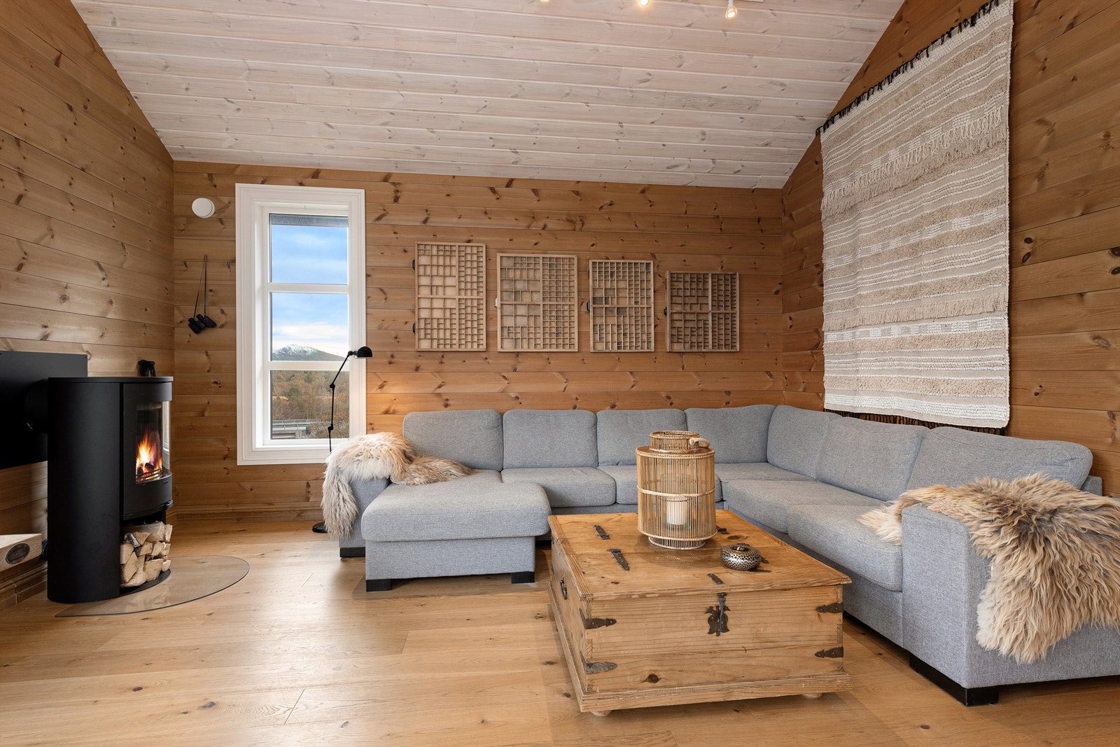 Koselig sofakrok på stuen med peisovn som gir en lun og hyggelig atmosfære Galleribilde