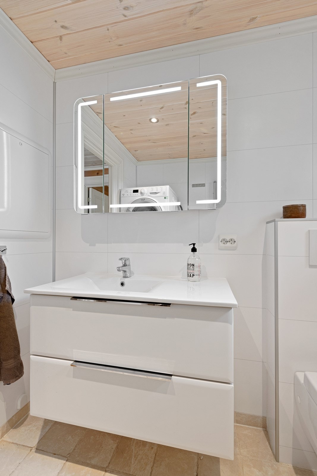 Sevantinnredning med skuffer og speil med lys over servant Galleribilde