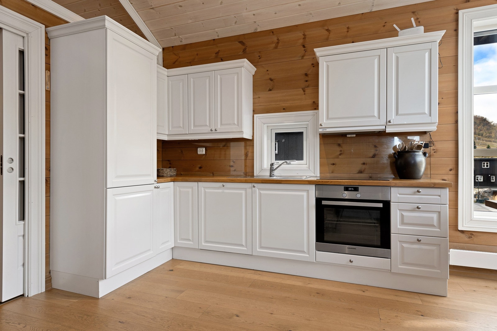 Hvit profilert kjøkkeninnredning med integrerte hvitevarer Galleribilde