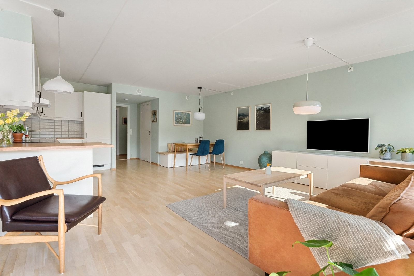 Boligens oppholdsrom er i en åpen stue- og kjøkkenløsning som gir et luftig allrom. Galleribilde