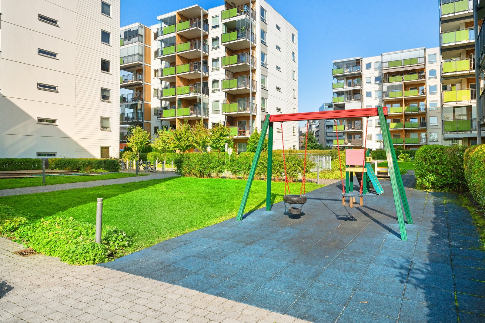 Her kan barna leke trygt på grønne og fine fellesområder med vannspeil og lekestativ kort vei fra leiligheten. Galleribilde