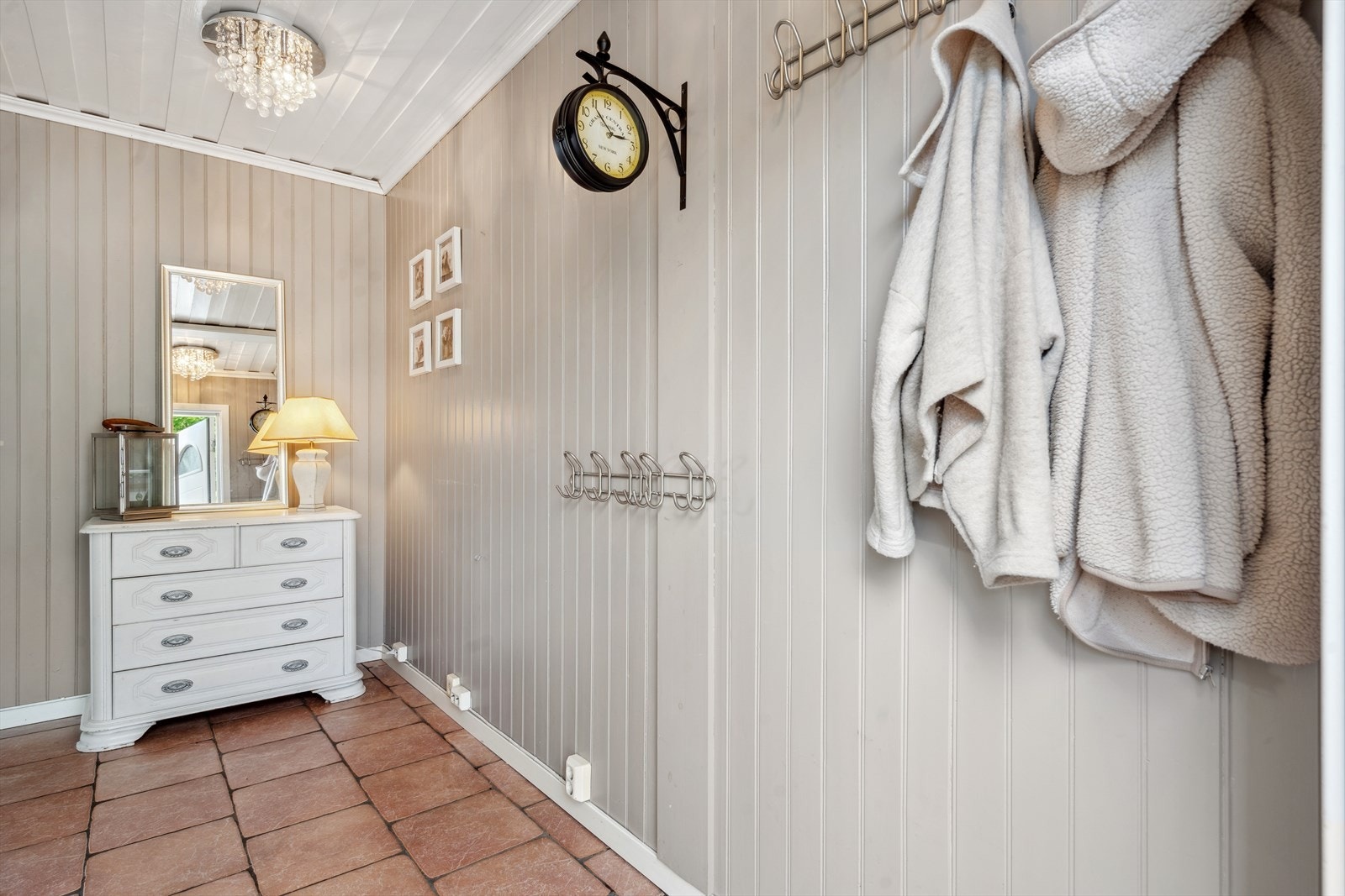 Gangen har fliser på gulv og vegger i moderne fargevalg. Galleribilde