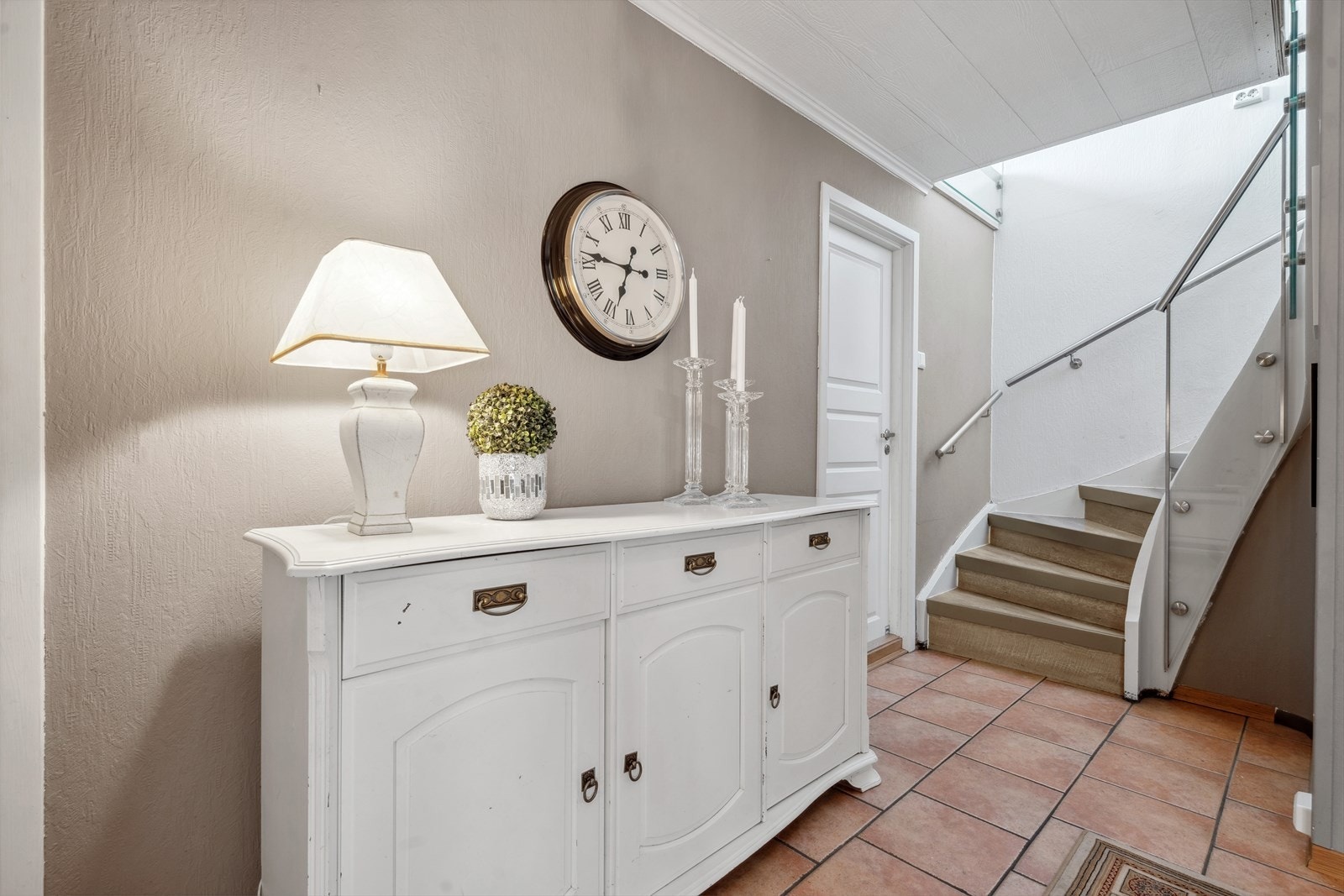 Trappeoppgangen er moderne med glassrekkverk og leder til boligens underetasje. Galleribilde