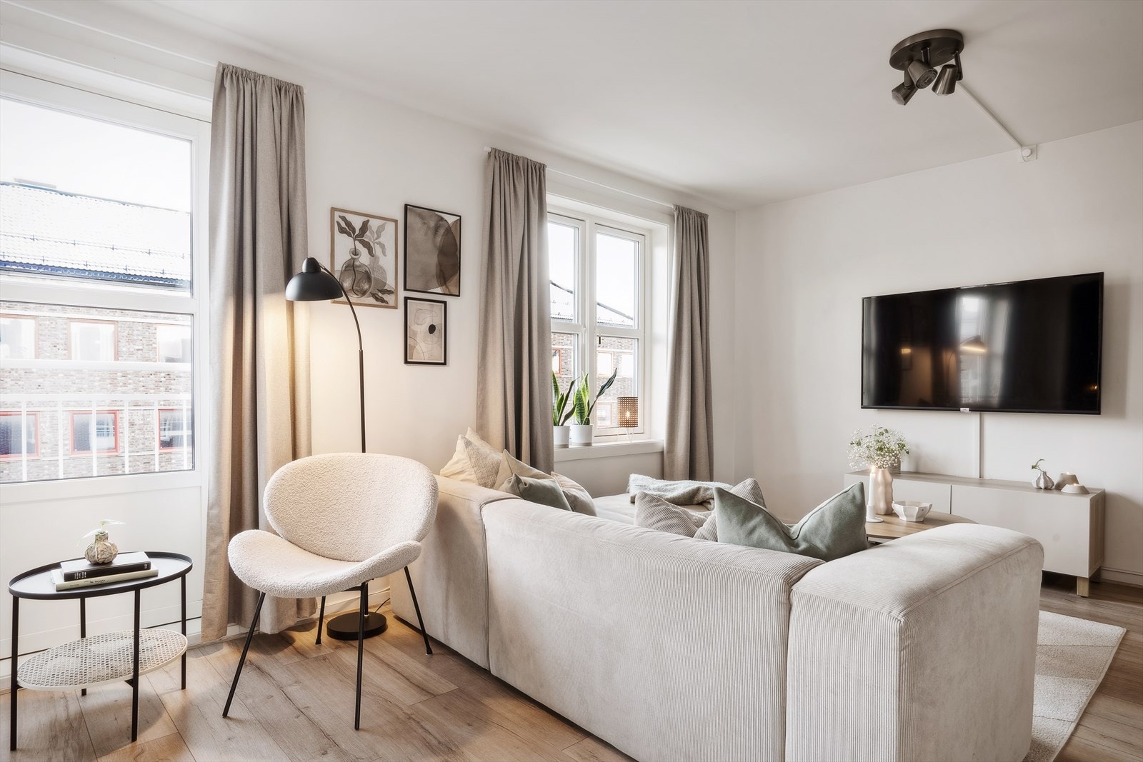 Dagslyset strømmer inn via store vinduer og balkongdører fra 2017. Galleribilde