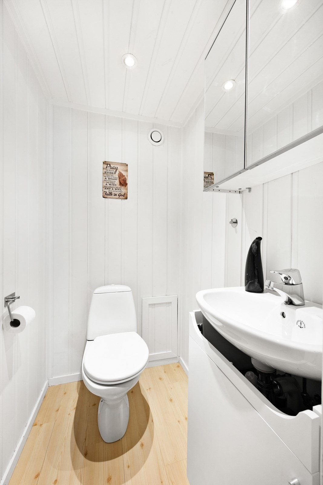 Toalettrommet har en innredning bestående av gulvmontert toalett, servant med underskap, og speilskap. Gulvet er belagt med parkett, og det er panel på både vegg og i tak. Galleribilde