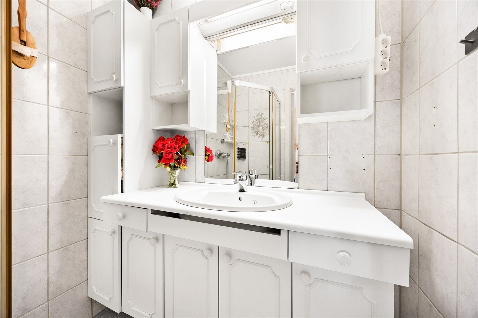 Baderommet er innredet med servant med tilhørende under- og veggskap, og speil med overlys. Galleribilde