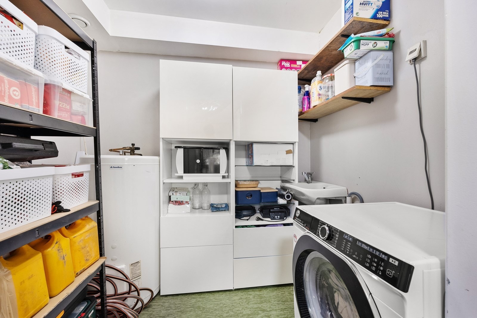 I tilknytning til kjøkkenet er det adkomst til leilighetens separate vaskerom. Vaskerommet er innredet med veggmontert servant, opplegg for vaskemaskin, og i hjørnet står det plassert en varmtvannstank på ca. 200 liter. Galleribilde