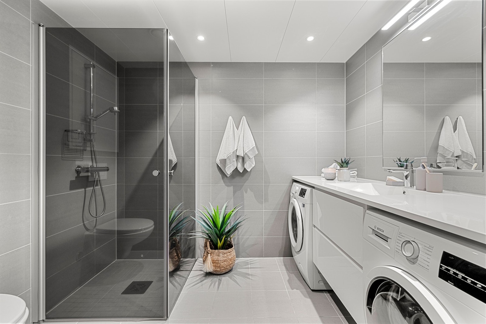 Badet har en elegant dusj med glassvegger og moderne innredning. Badet har også nedfelt servant, veggmontert toalett og gulvvarme. Galleribilde