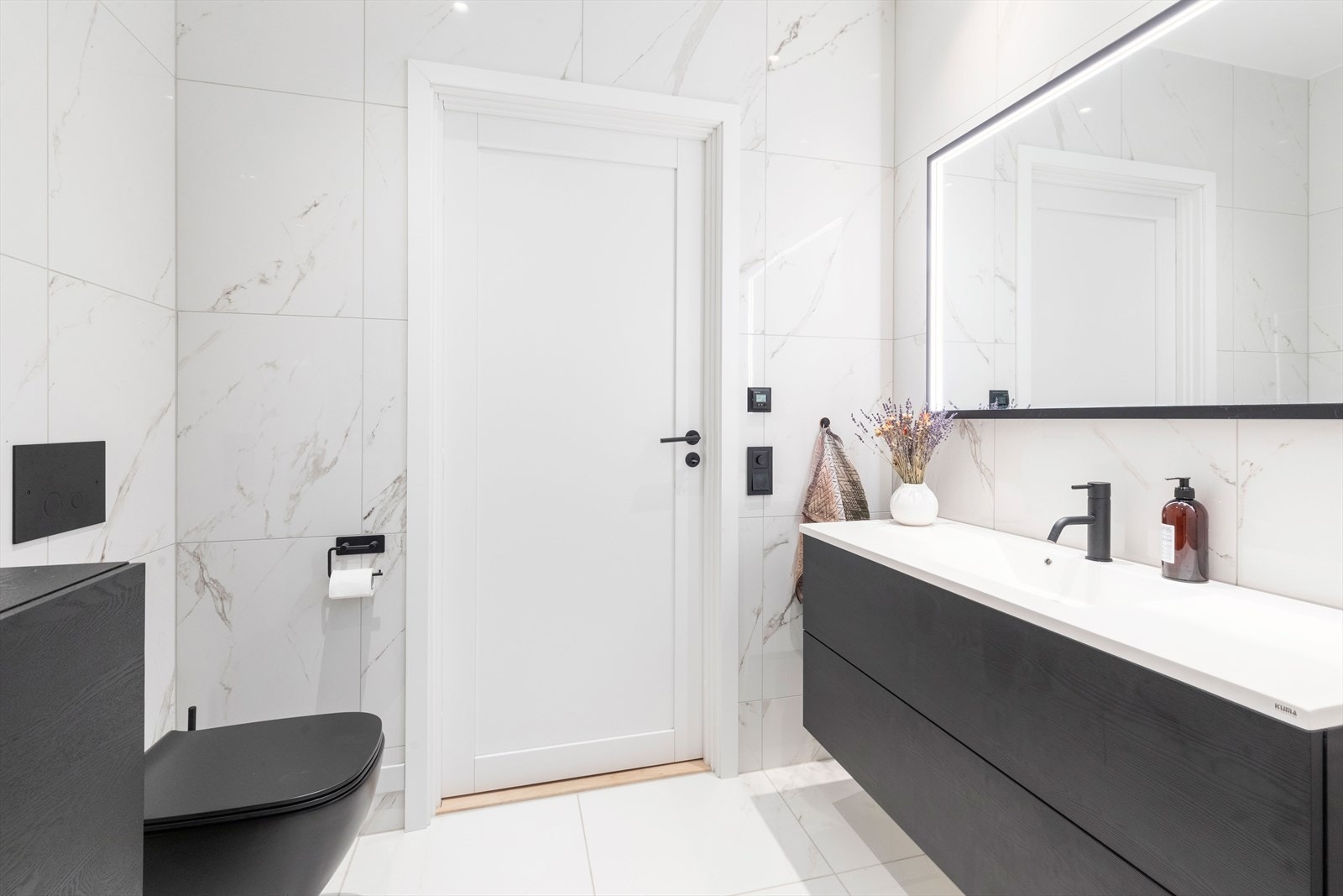 Badet er innredet med et servantinnredning, speilskap med integrert lys, dusjnisje med glassdør og vegghengt toalett. Galleribilde