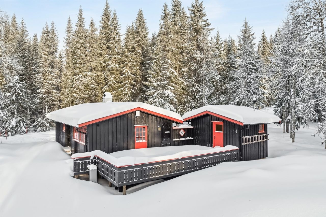 Hytta har stor sammenhengende terrasse mellom hytte og bod. Skjermende vegg gjør terrassen lun og skjermet. Galleribilde