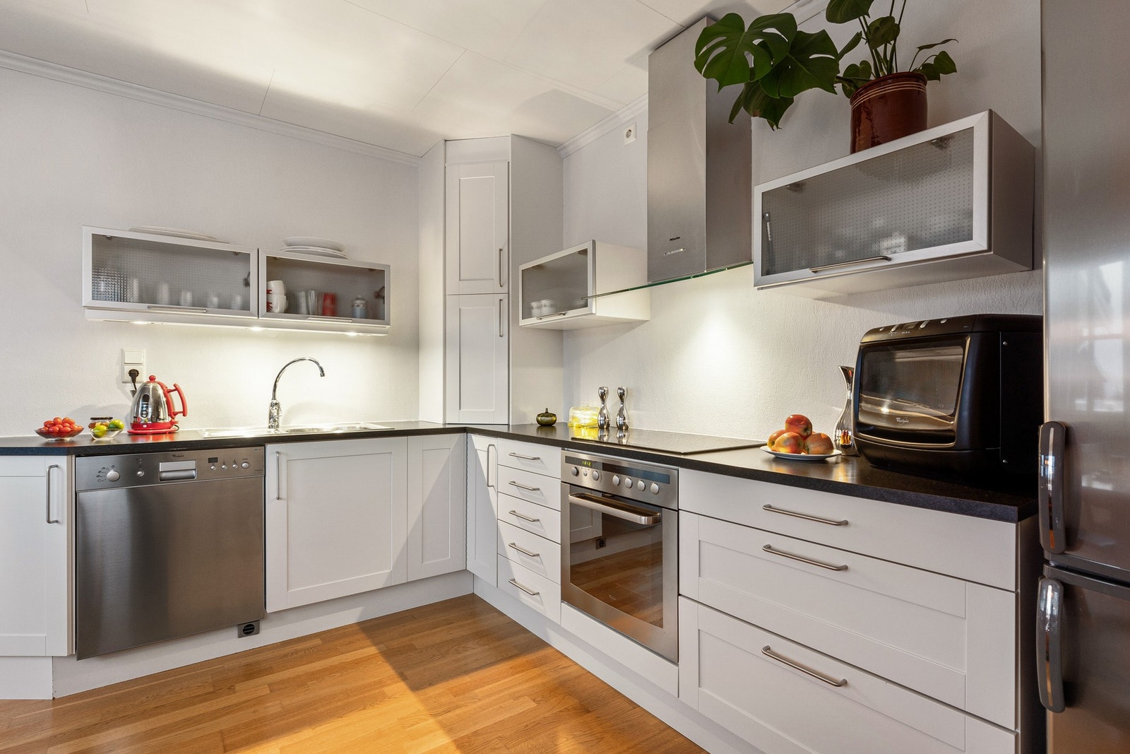 Kjøkkenet har integrerte hvitevarer som oppvaskmaskin, stekeovn og koketopp Galleribilde