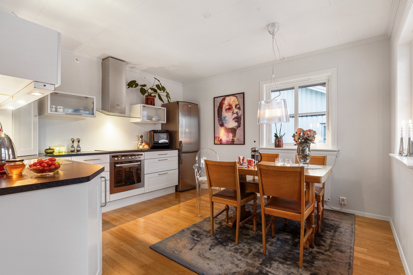 Rosmlig kjøkken med gode arbeidsflater og plass til spisebord Galleribilde