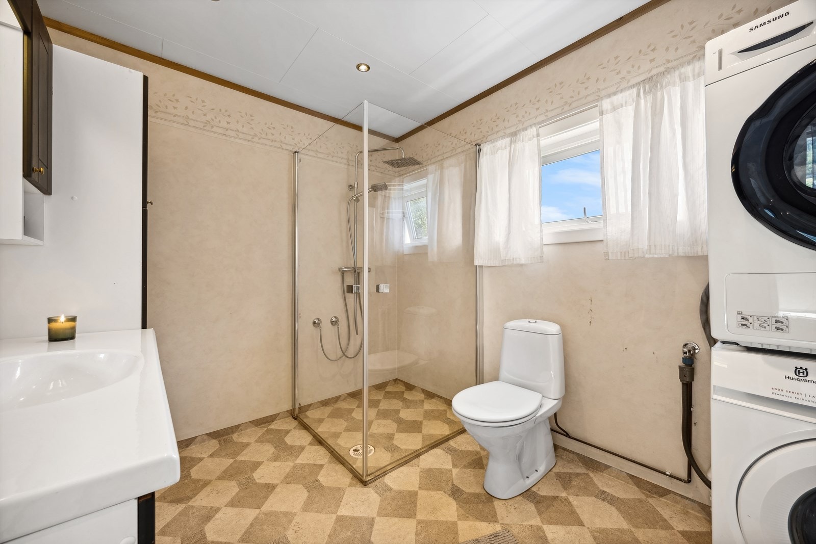 Rommet har servant med skap, speil og lys, dusj med foldbare dusjdører, gulvmontert toalett og opplegg til vaskemaskin. Galleribilde