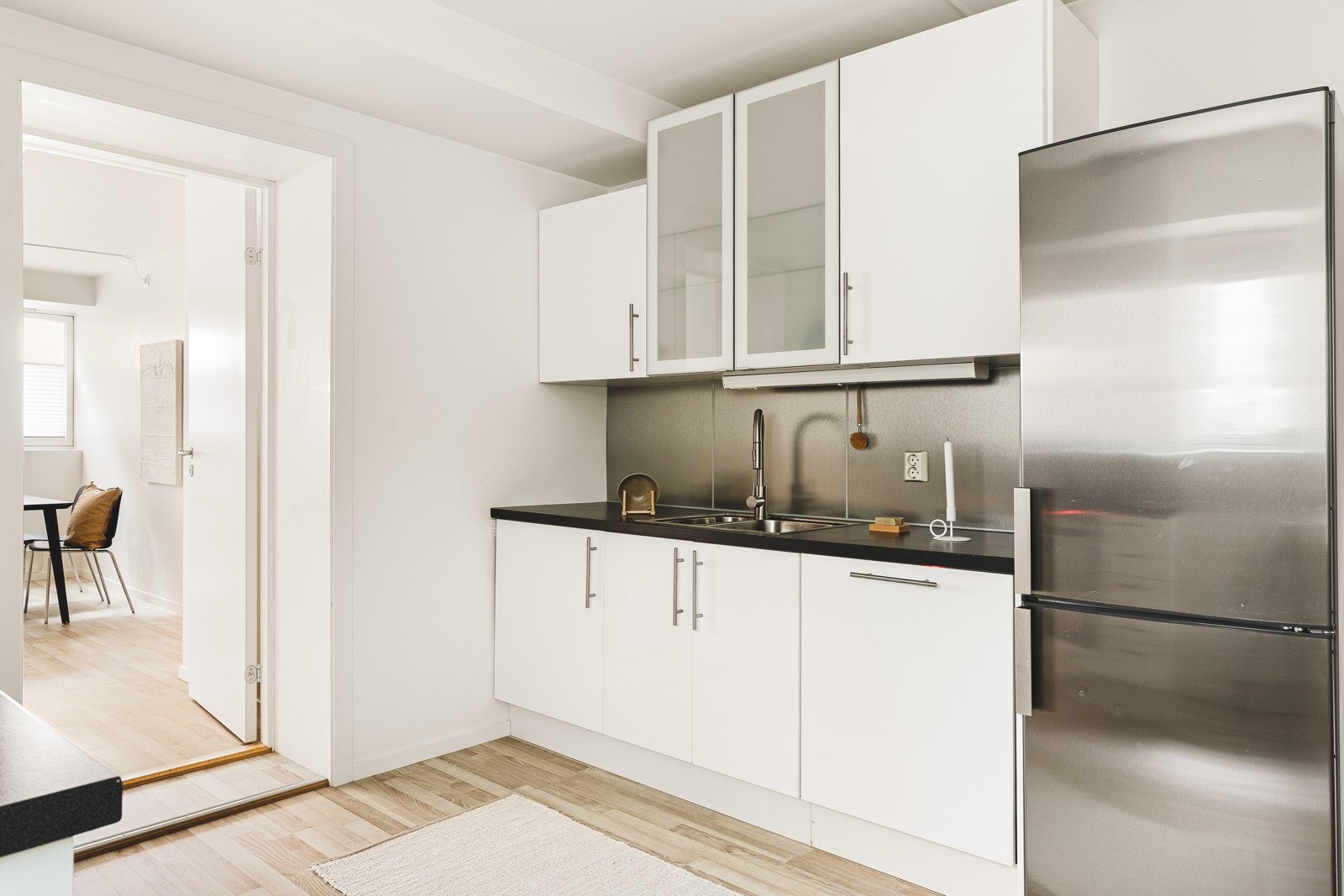 Kjøkkeninnredning består av slette fronter, ett glasskap og laminat benkeplate med nedfelt vask av stål. Galleribilde