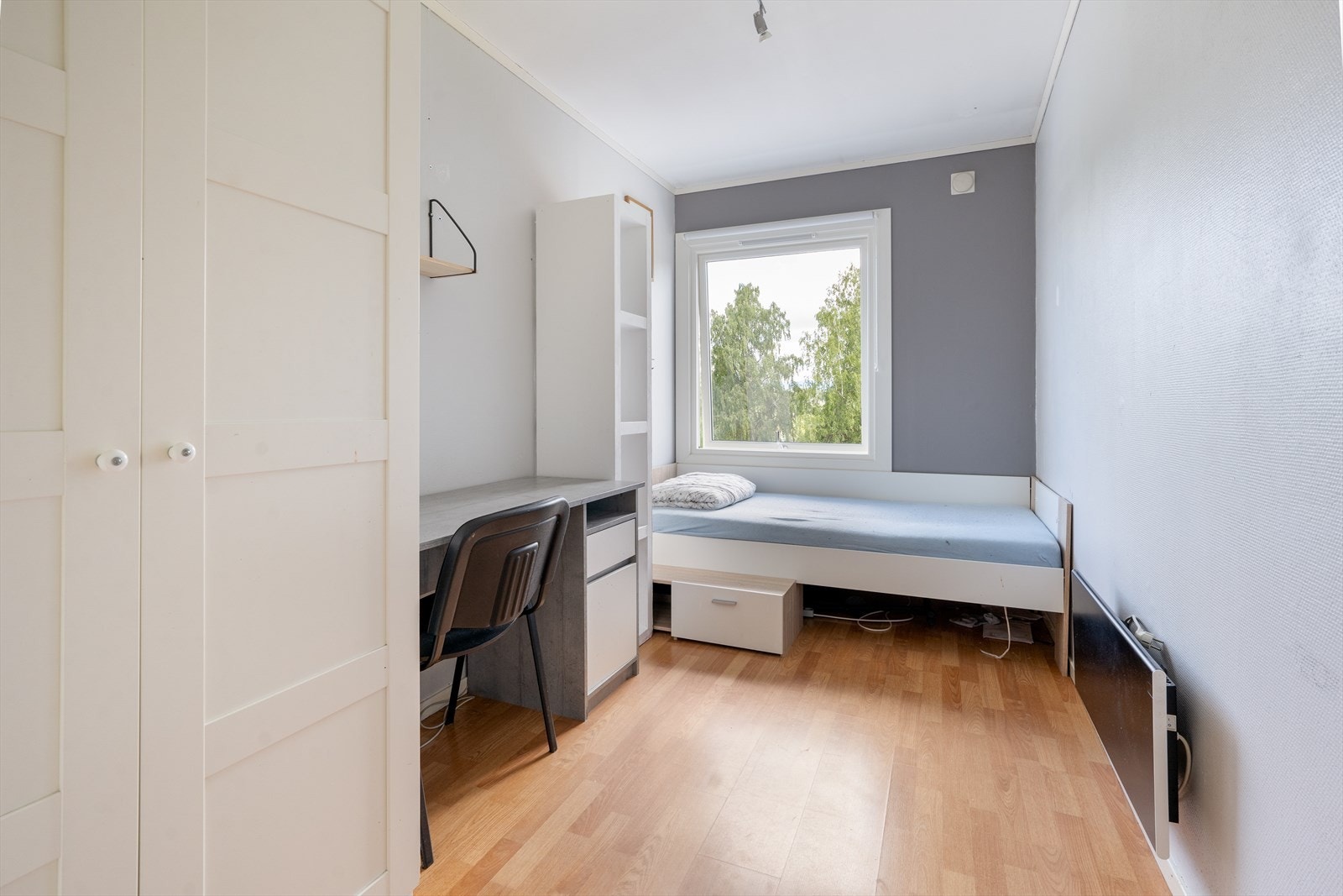 Soverom nr. 2 er 8 kvm stort, og har laminat på gulv og malt tapet på vegger. Her er det garderobeskap, panelovn og rullegardin. Galleribilde