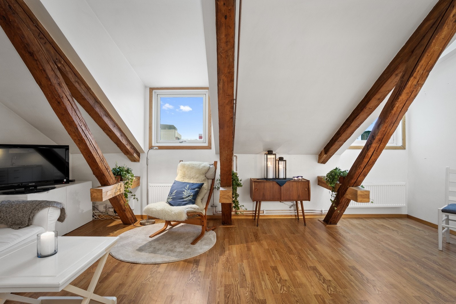 Stuen har naturlig lysinnfall fra vinduene og takvinduene i leiligheten Galleribilde