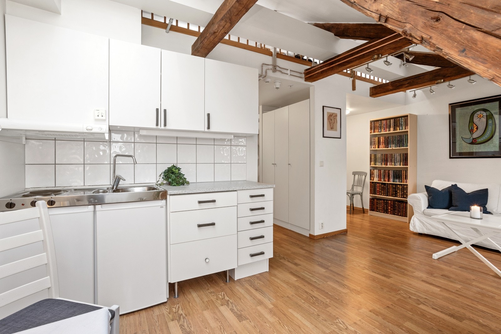 Kjøkkeninnredningen har hvite, slette fronter med benkeplate av laminat. Galleribilde