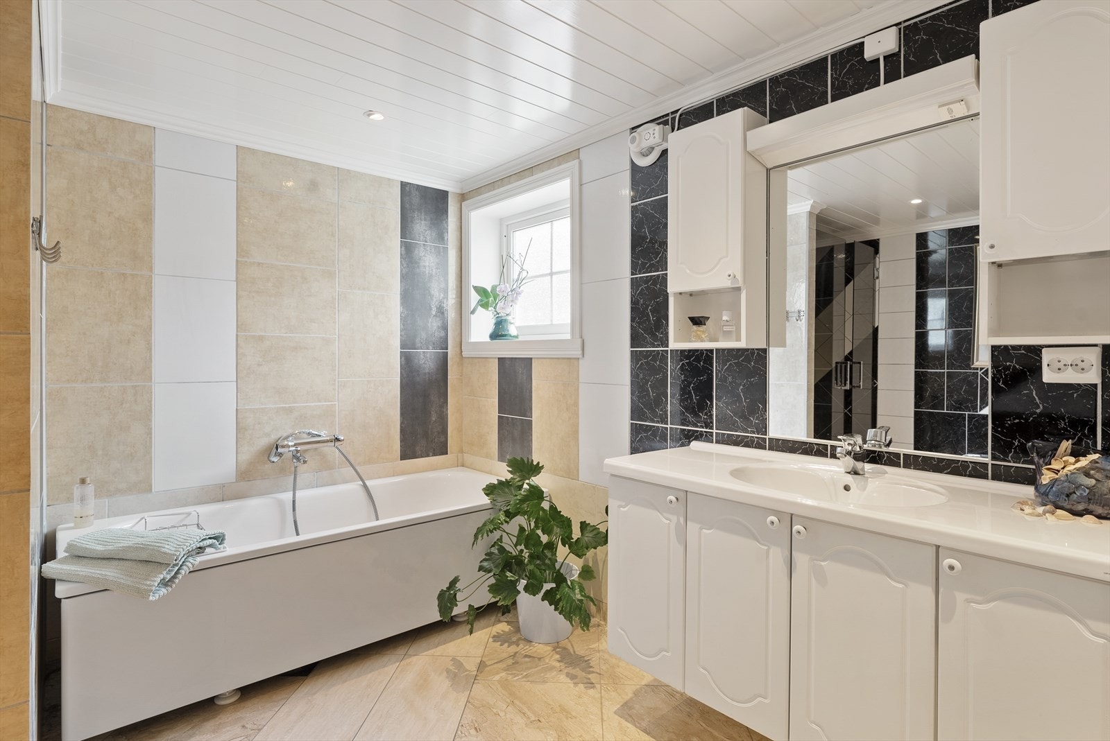 Stor regnfallsdusj i nisjé, badekar etablert på siden. Baderomsinnredningen har god oppbevaringsplass. Galleribilde