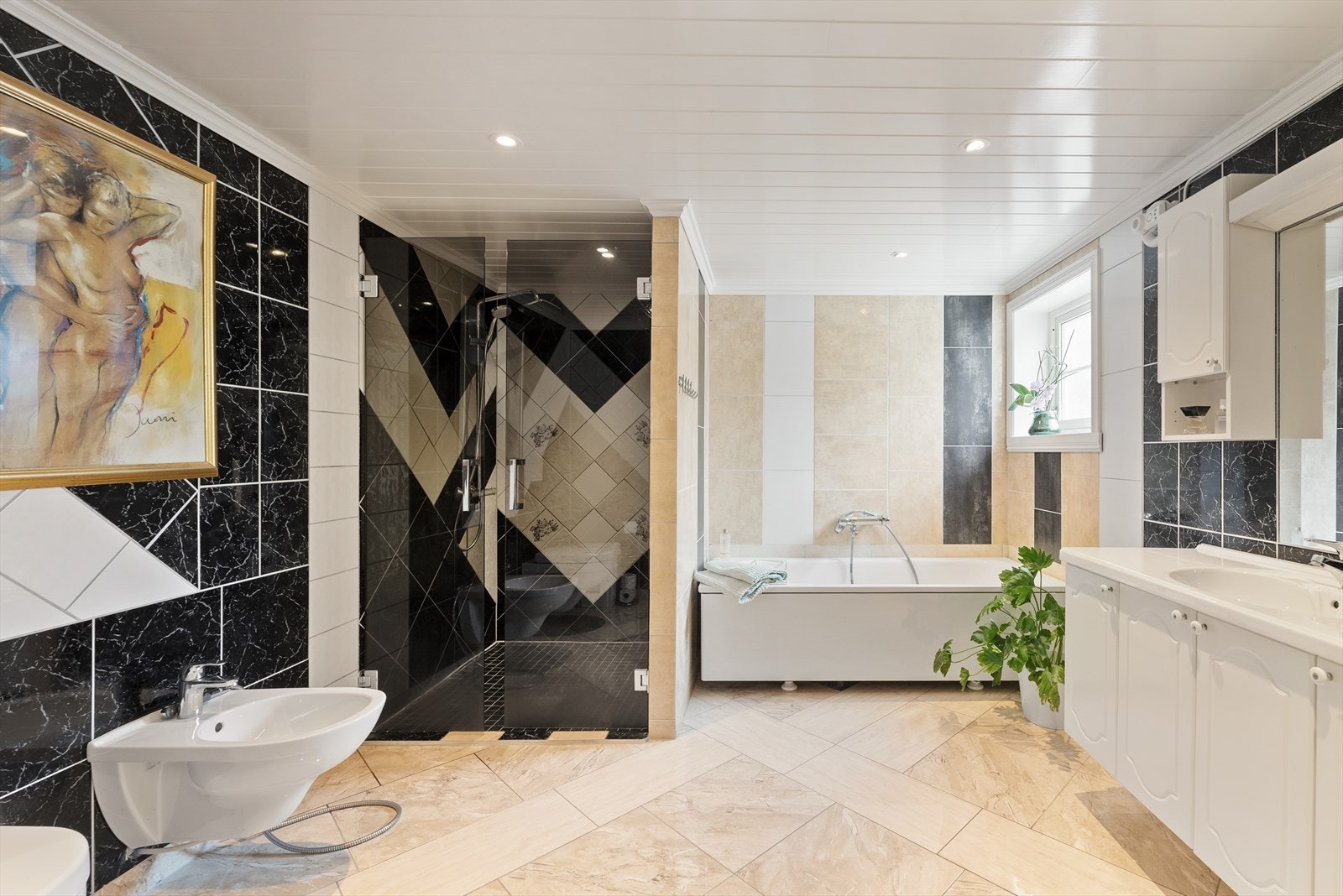 Stort bad i 1. etasje med gjennomgående bruk av store, stilige fliser. Badet oppleves som tidløst. Galleribilde