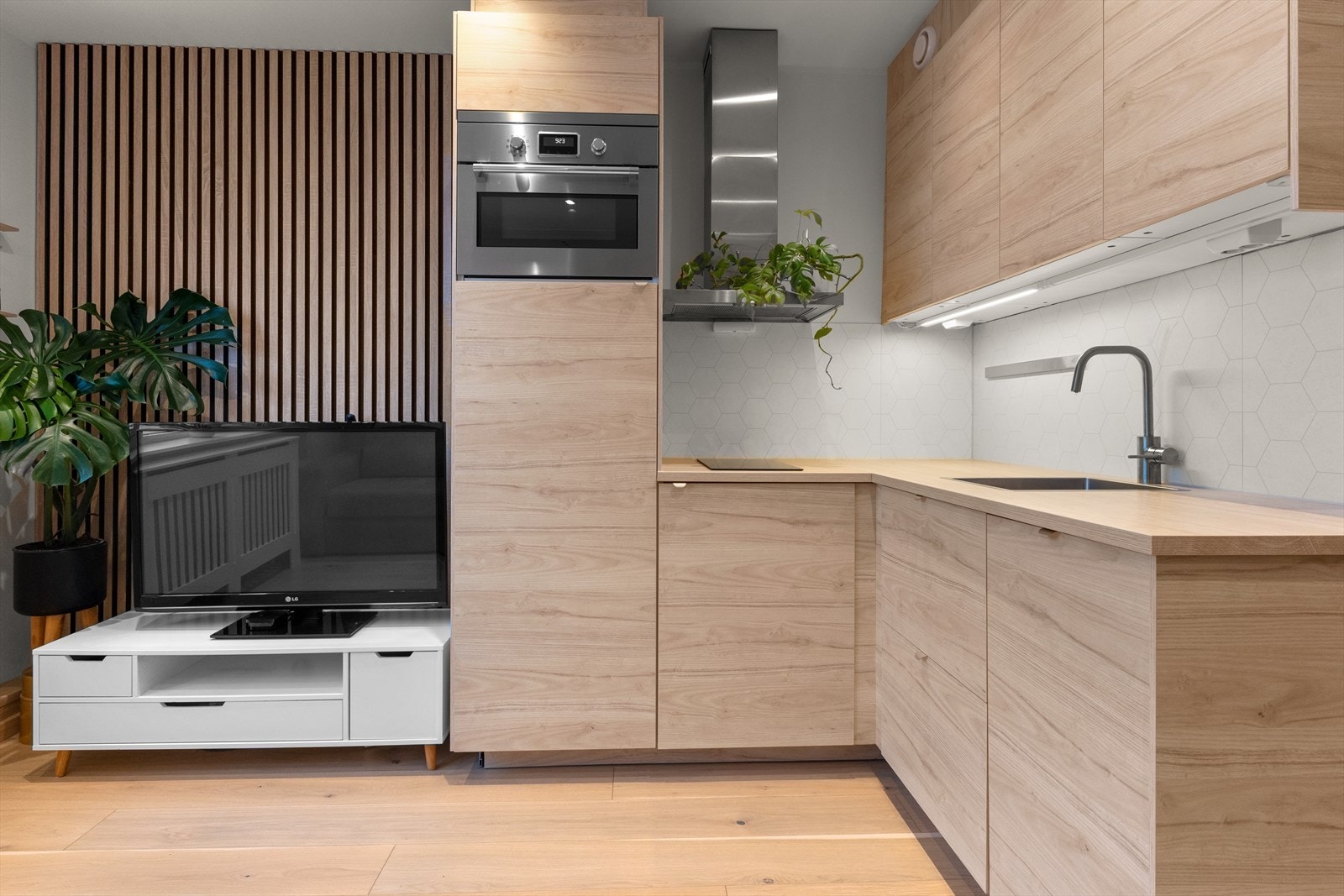 Pent kjøkken fra 2022 med glatte fronter og foliert benkeplate. Galleribilde