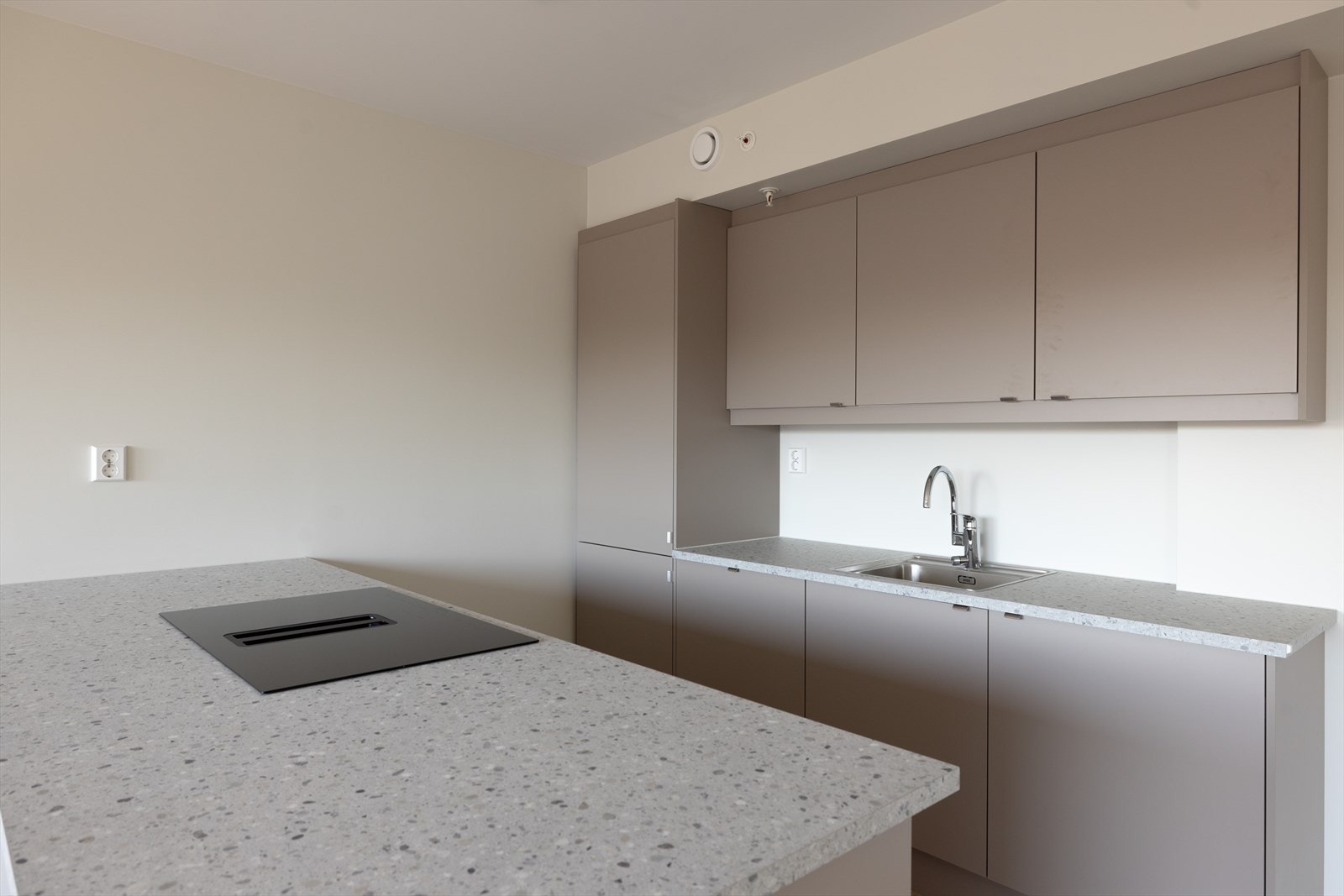 Gode arbeidsflater på kjøkkenøy samt under overskap på motsatt side. Det er nedfelt oppvaskkum og nedfelt induksjonstopp med integrert kjøkkenventilator med plassmafilert. Galleribilde