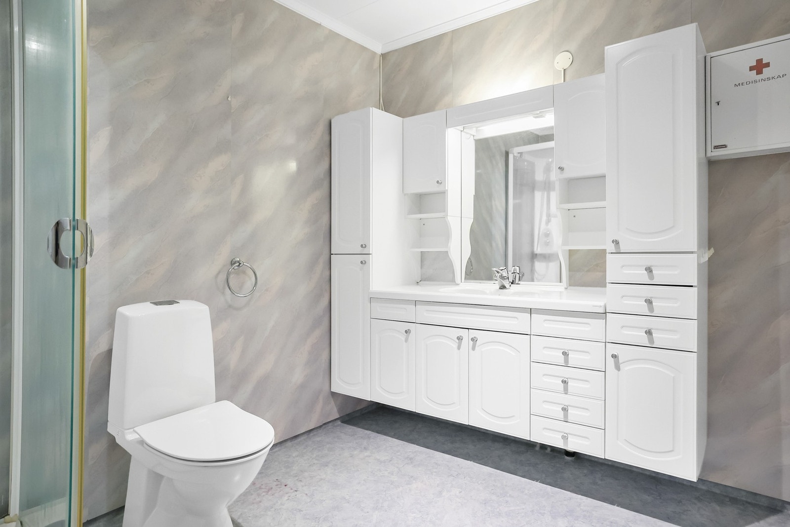 Badet er lyst, og har baderomsplater på veggene og gulvflate med gulvbelegg. Galleribilde