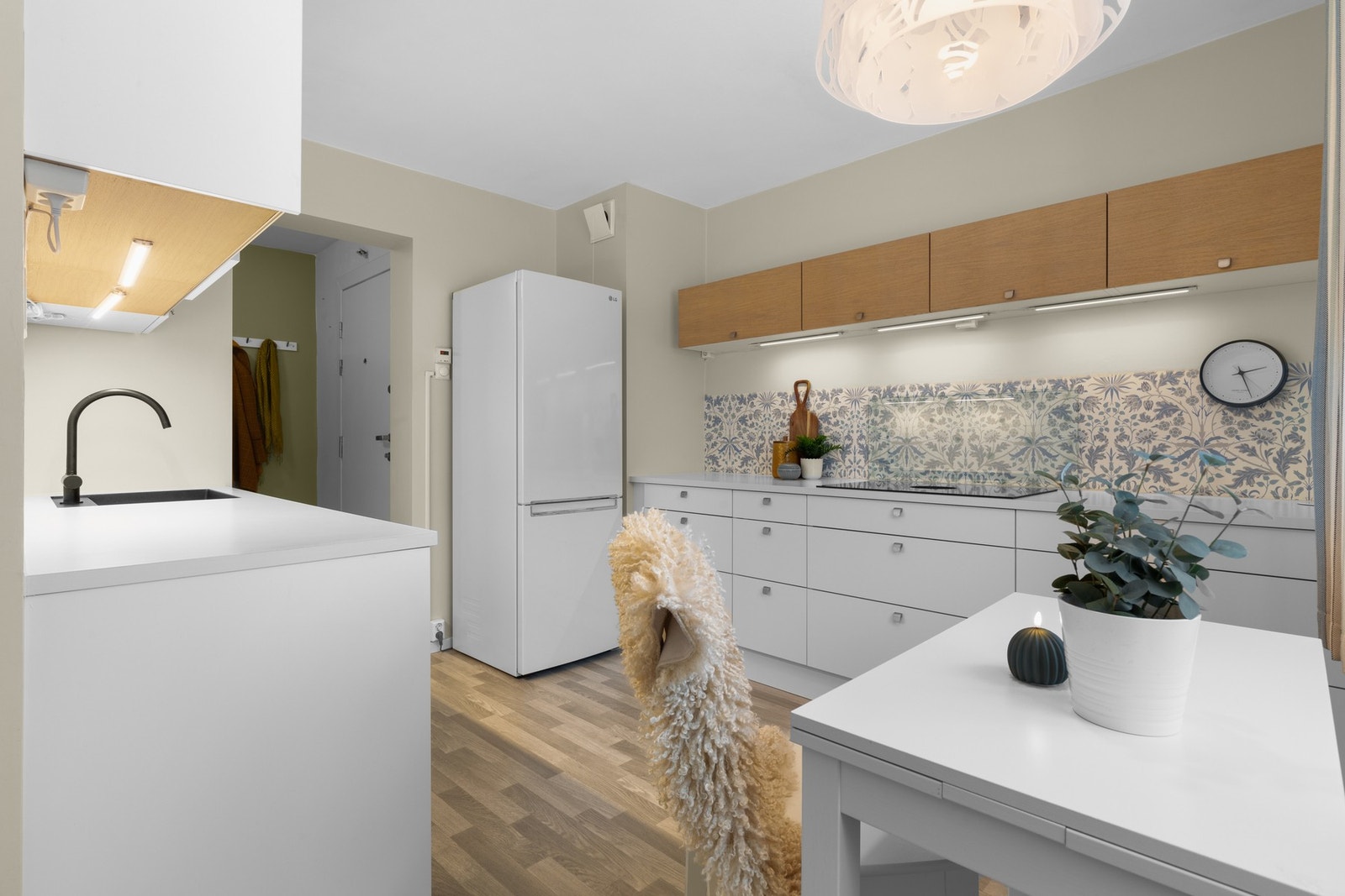 Kjøkkenet er oppgradert i 2019 med moderne, hvite glatte fronter og en benkeplate i laminat. Her finner du integrerte hvitevarer som komfyr, platetopp med avtrekk og oppvaskmaskin, i tillegg til et frittstående kjøl-/fryseskap (som ikke medfølger). Galleribilde