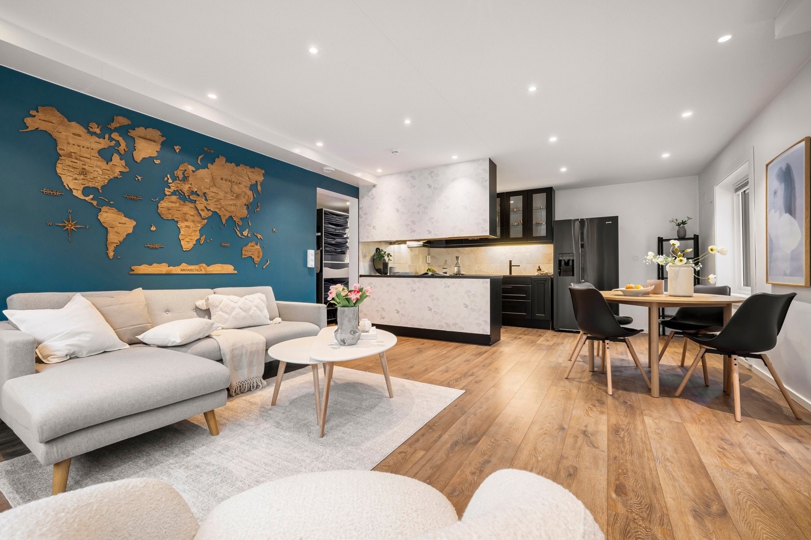 Sofaen får sin naturlige plassering langs den ene veggen, mens det er plass til et lite spisebord i overgangen mot kjøkkenet. Galleribilde