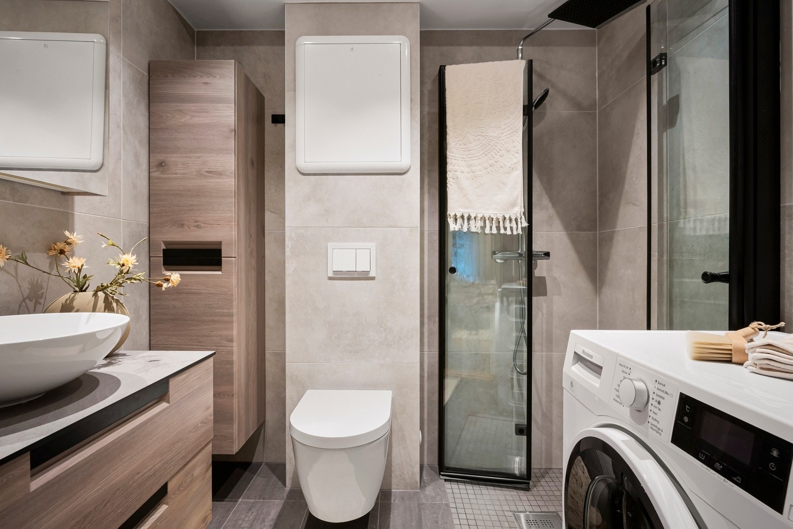 Innredningen består av benkeskap med servant, dusjdører, vegghengt toalett og opplegg for vaskemaskin. Galleribilde