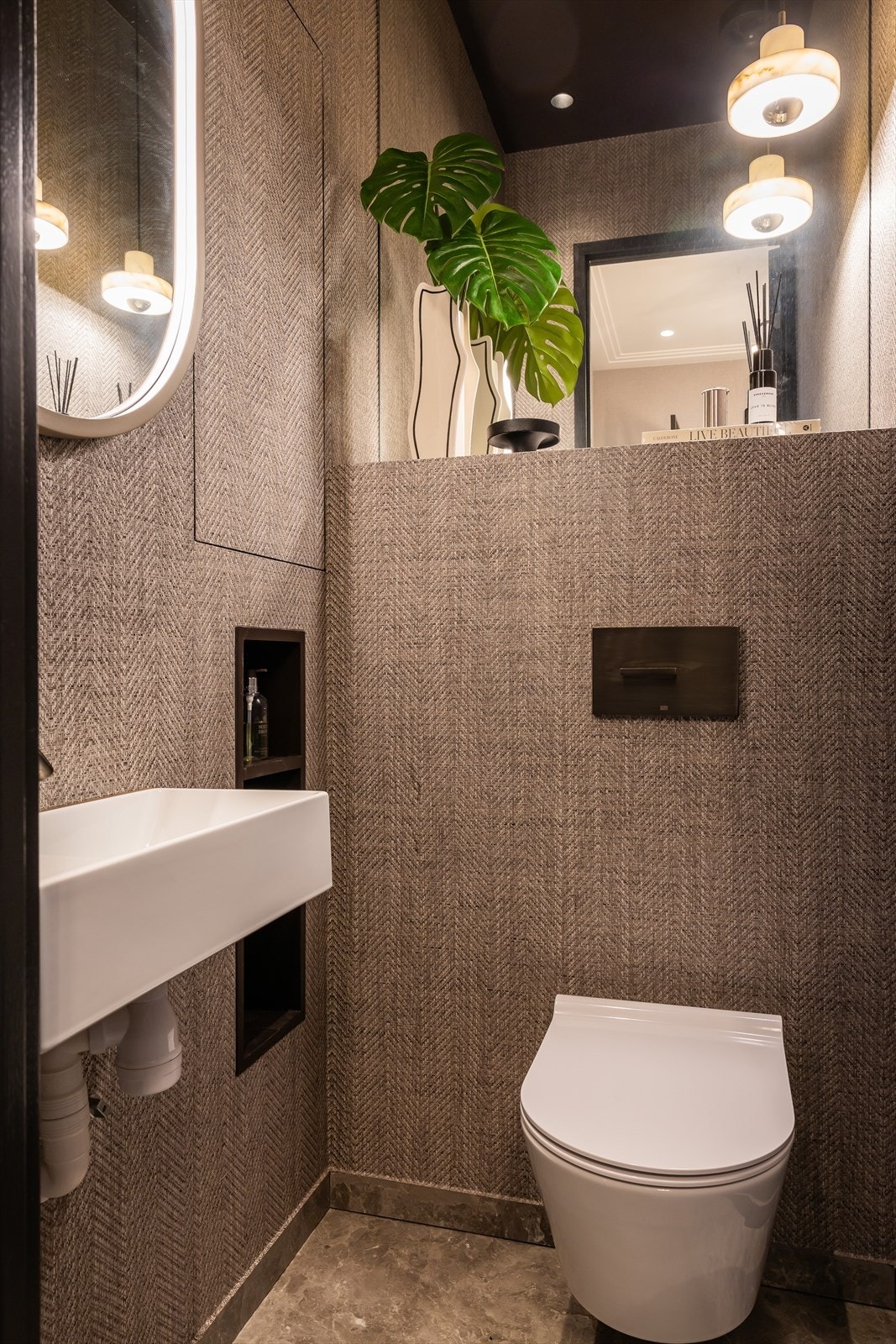 Servant og WC i eksklusiv porselen fra Catalano med betjeningspanel i dark platinum matt fra Dornbracht. Galleribilde