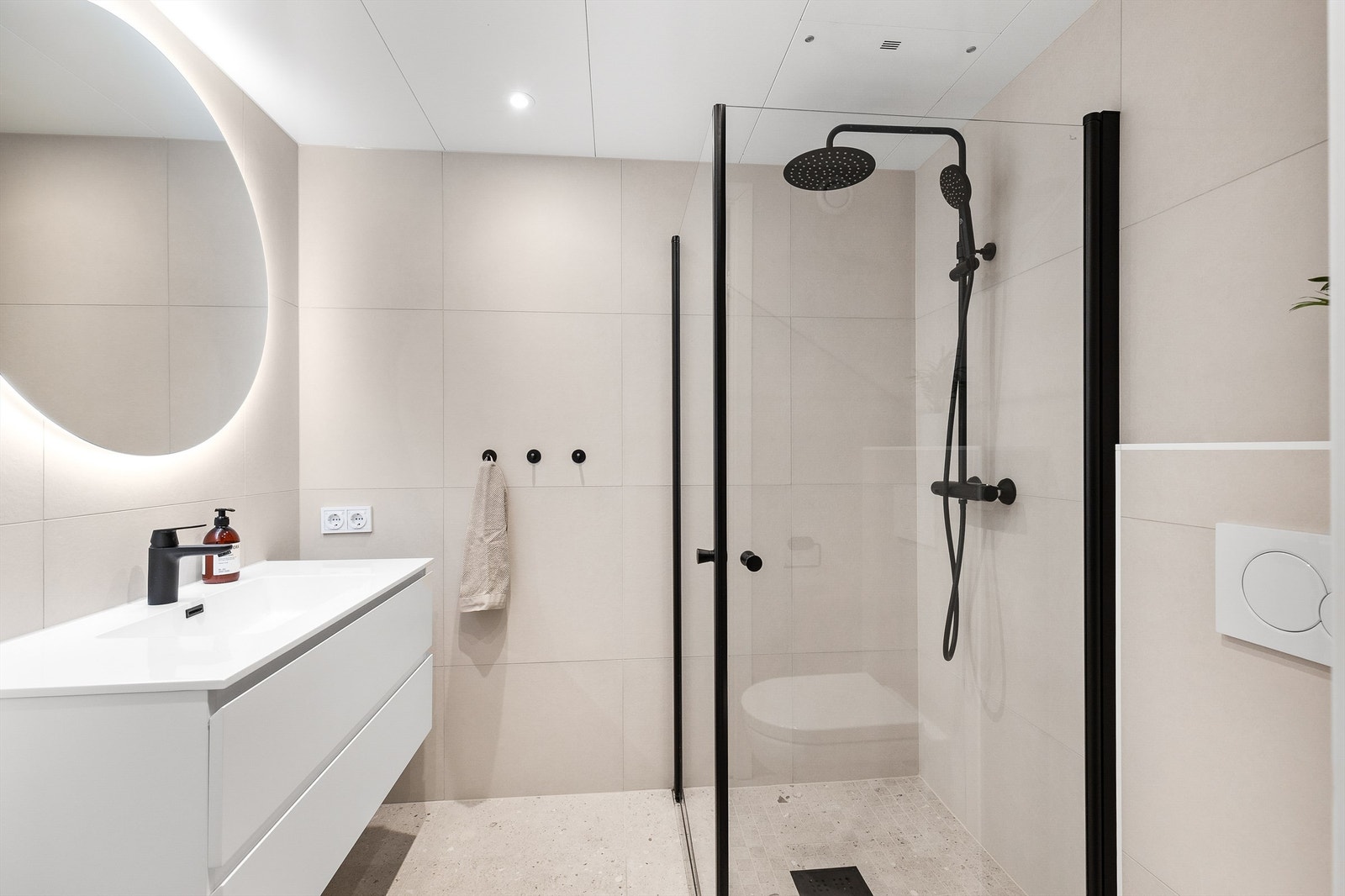 Badet er flislagt på gulv og vegger med elektrisk gulvvarme. Begge boligens bad er nye i 2023. Galleribilde