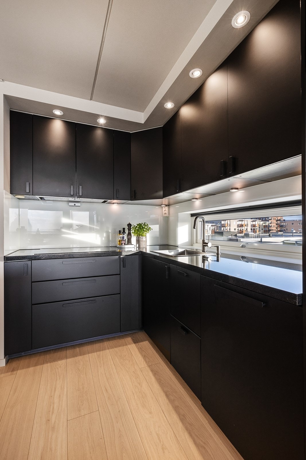 Takhøye overskap gir mye oppbevaringsplass med belysning over benkeplaten. Galleribilde