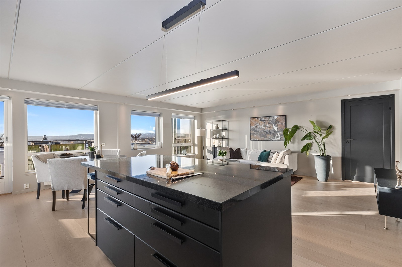 Det mørke kjøkkenet gjør at rommet naturlig deles inn i to soner. Galleribilde