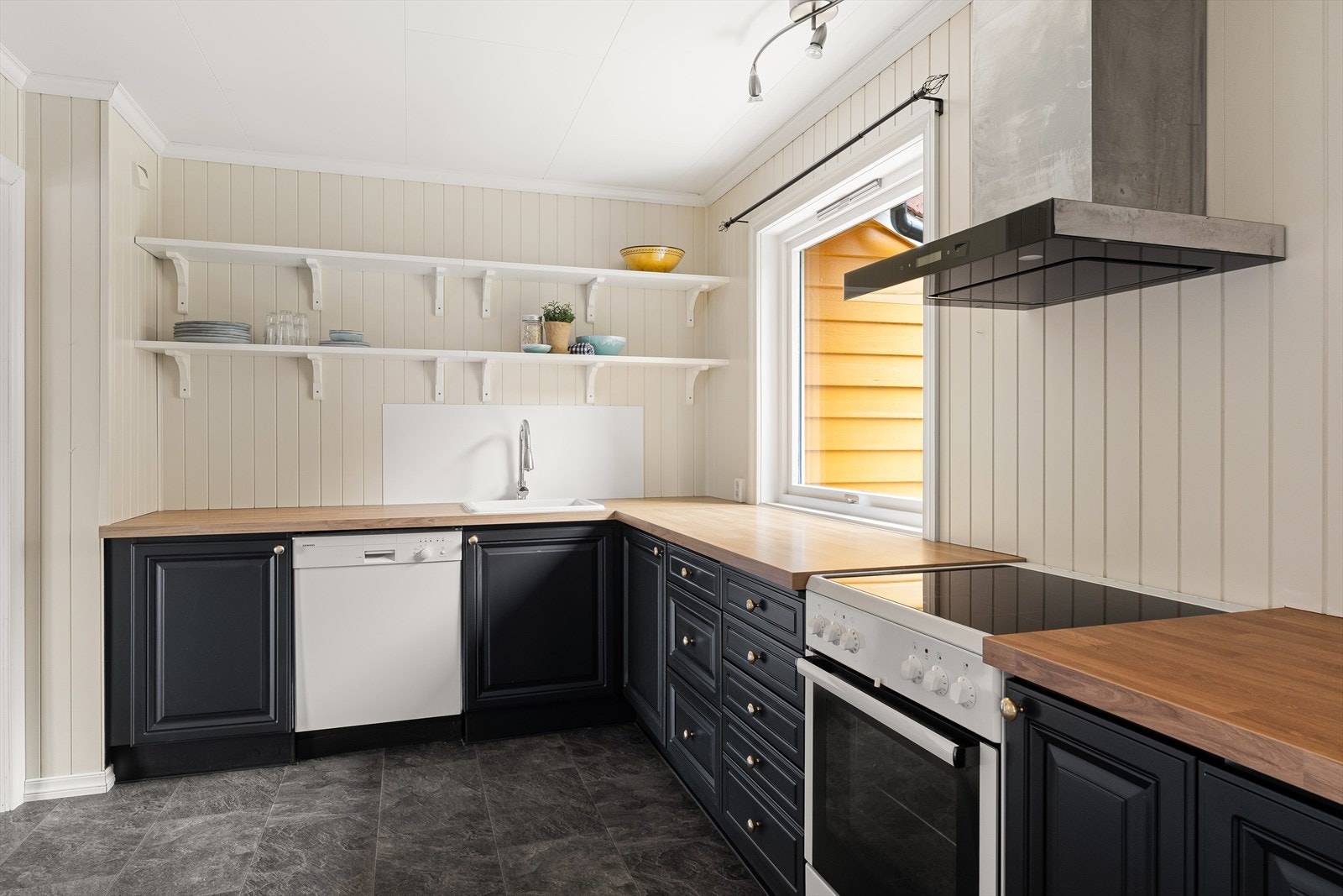 Kjøkkeninnredning med profilerte fronter og laminert benkeplate. Galleribilde