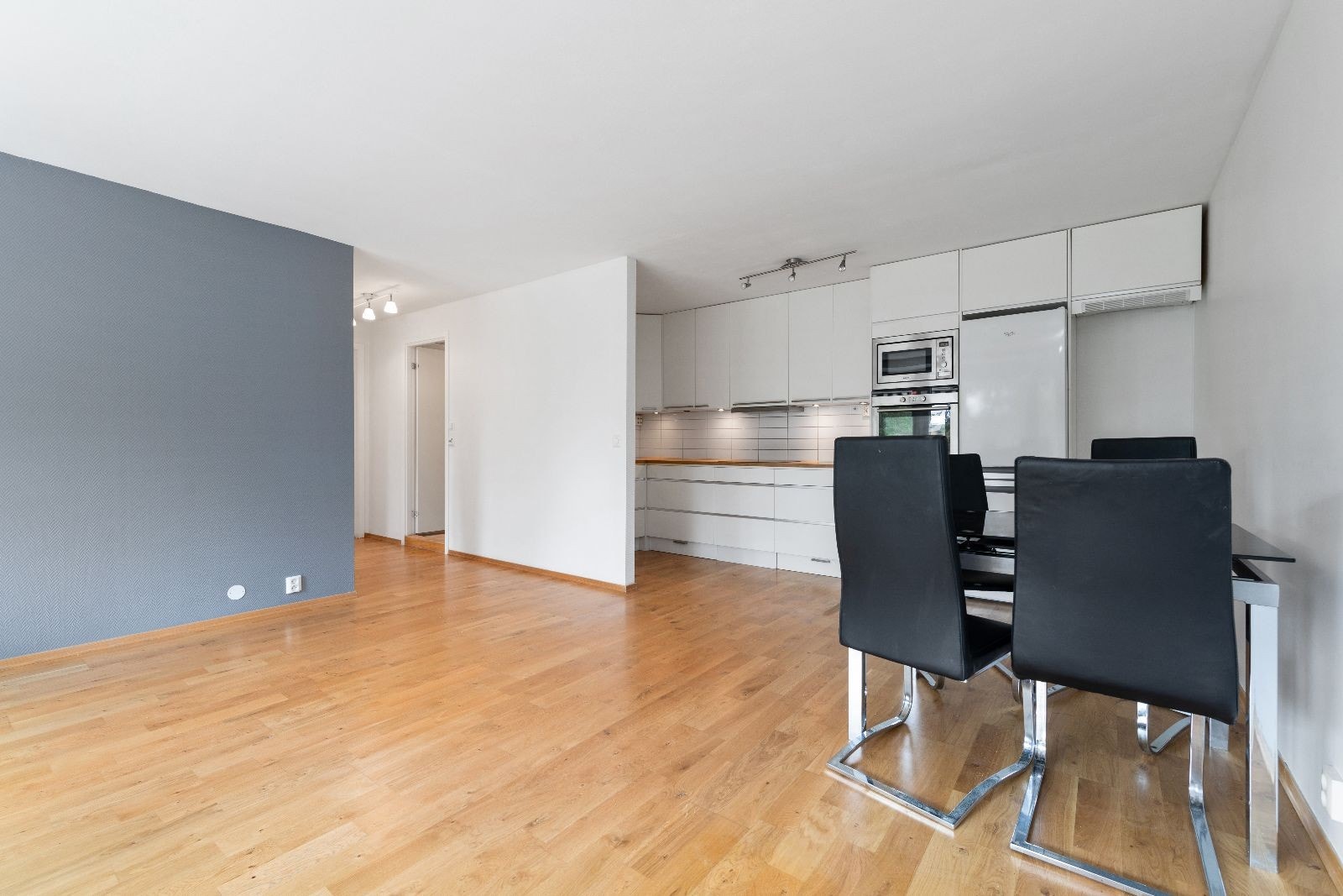 Åpen kjøkken/stueløsning med plass til både spisestue og TVstue. Grå vegg er malt beige. Galleribilde