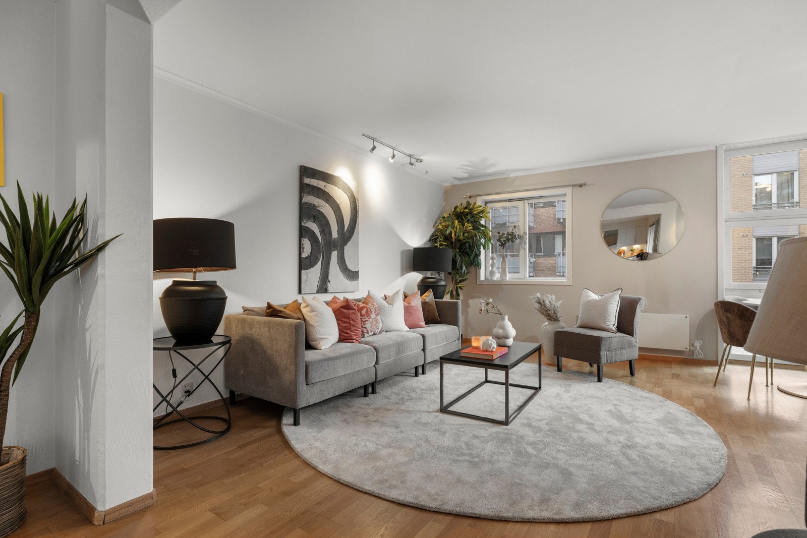 Stuen i leiligheten er romslig og flott opplyst med store vindusflater som gir rikelig med naturlig lys, og skaper en god atmosfære. Galleribilde