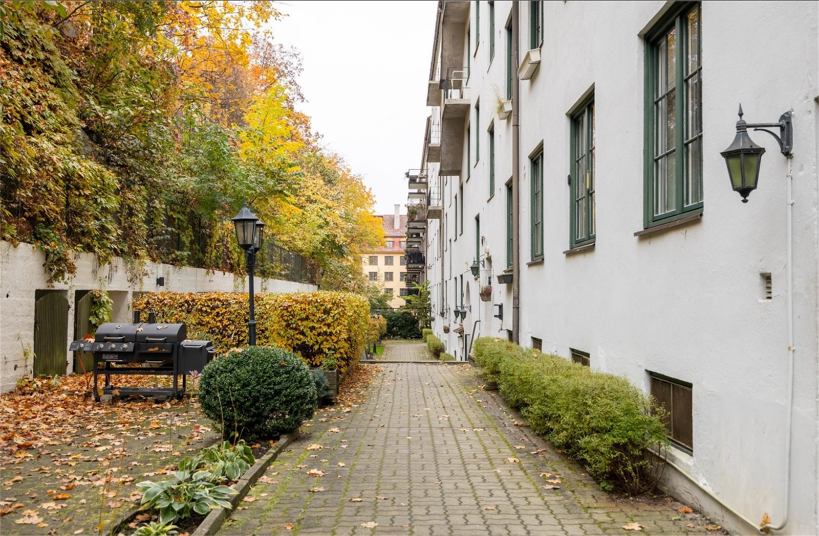 Bakgården er opparbeidet med blant annet belegningsstein, gressplen, sykkelstativer og prydbusker. Galleribilde