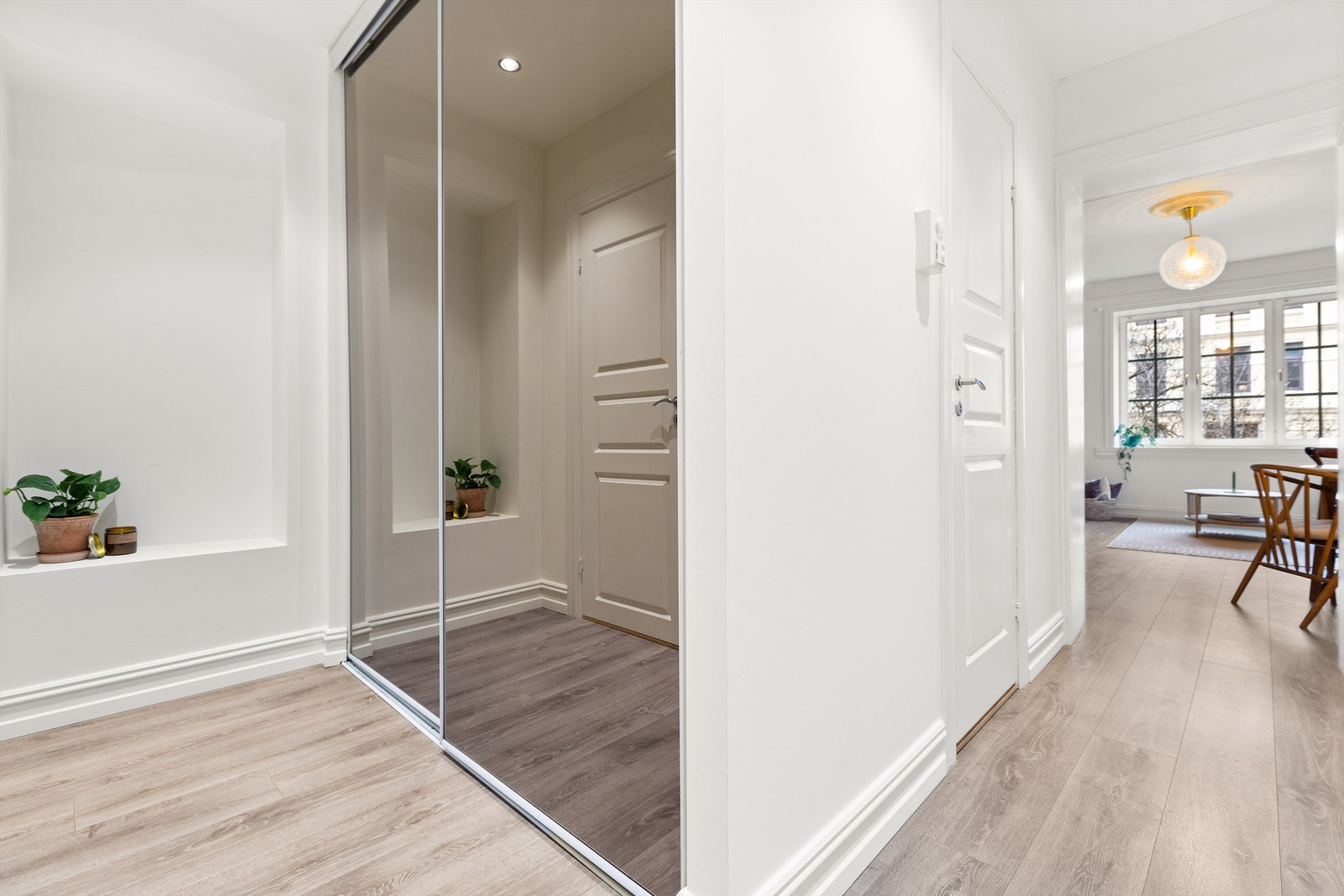 Entréen er innredet med praktiske skyvedørsgarderobe med speil. Garderoben er praktisk plassert for enkel tilgang, og gir en ryddig og organisert følelse. Galleribilde