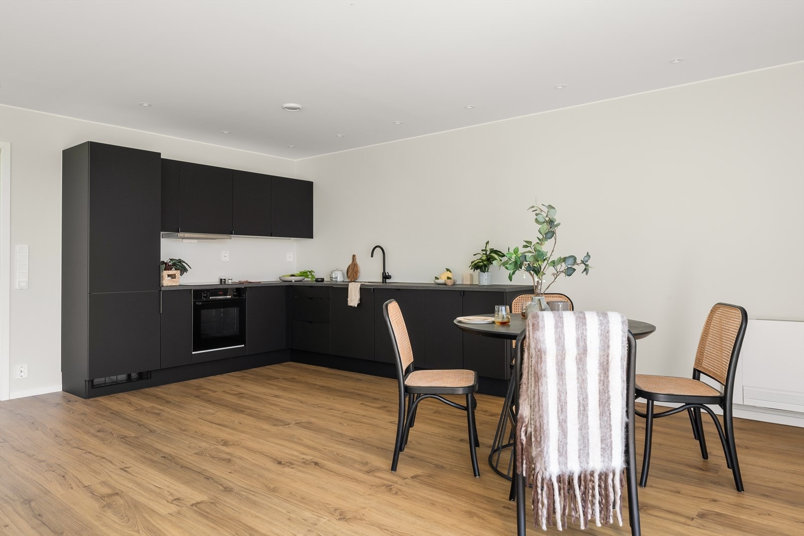 Tidløst kjøkkeninnredning med glatte fronter og benkeplate av laminat. Galleribilde