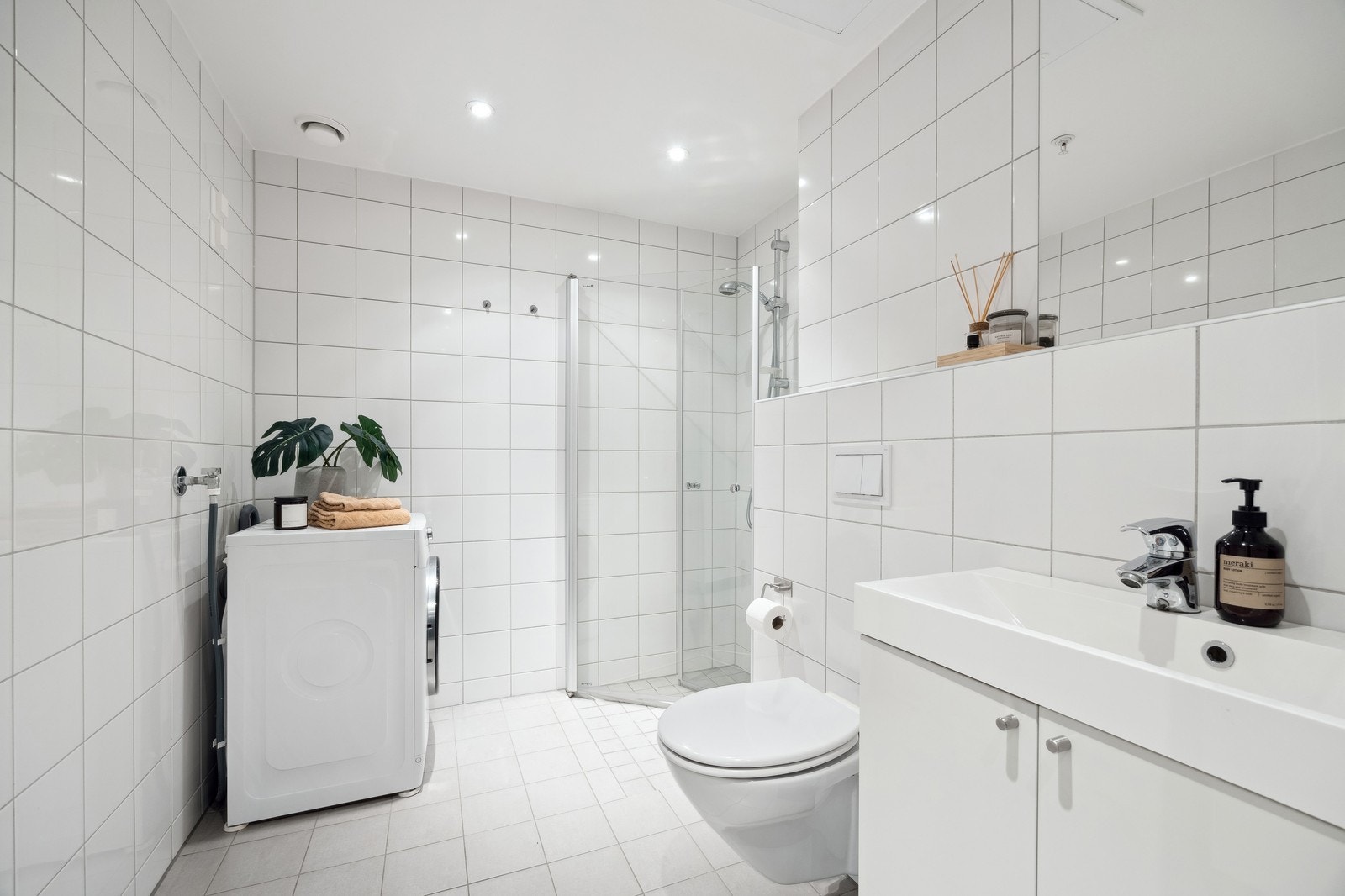 Bad med vaskemaskin, dusj, servant og toalett. Galleribilde