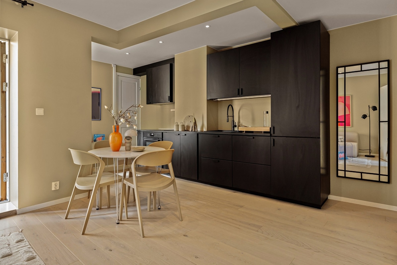 Åpen stue/kjøkkenløsning gjør rommet luftig. Stilren stram kjøkkeninnredning. Galleribilde