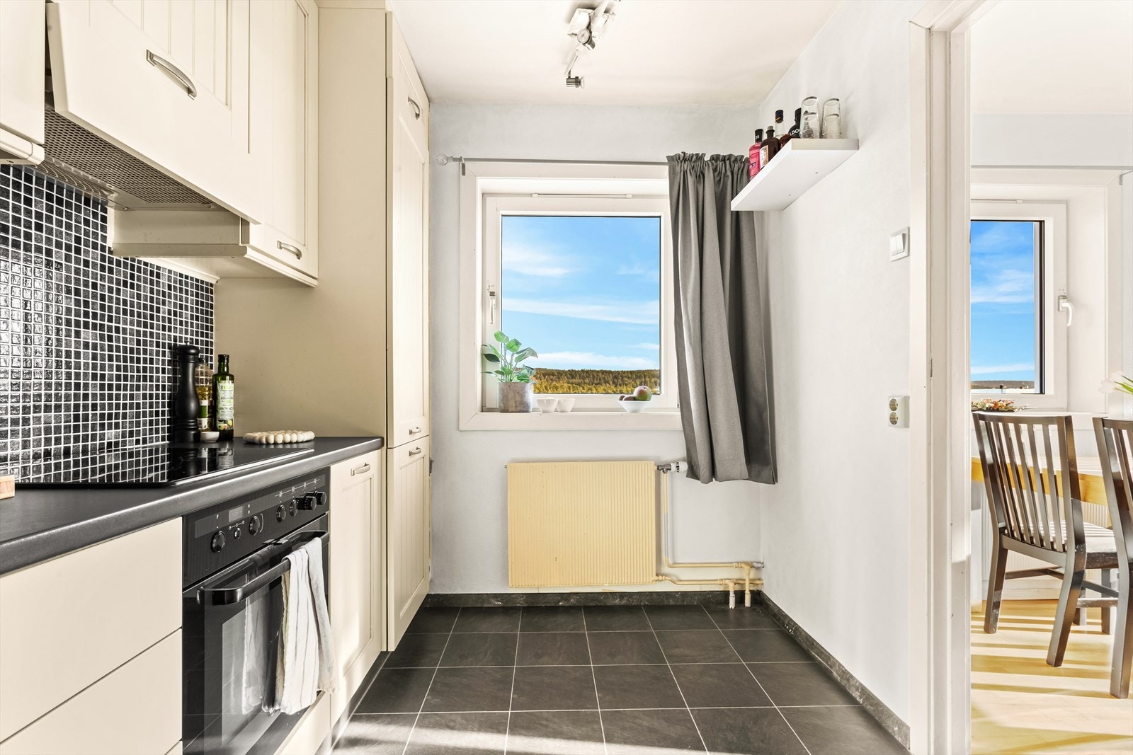 Kjøkkenet har også mosaikkfliser på veggen over kjøkkenbenken og belysning under overskapene. Galleribilde