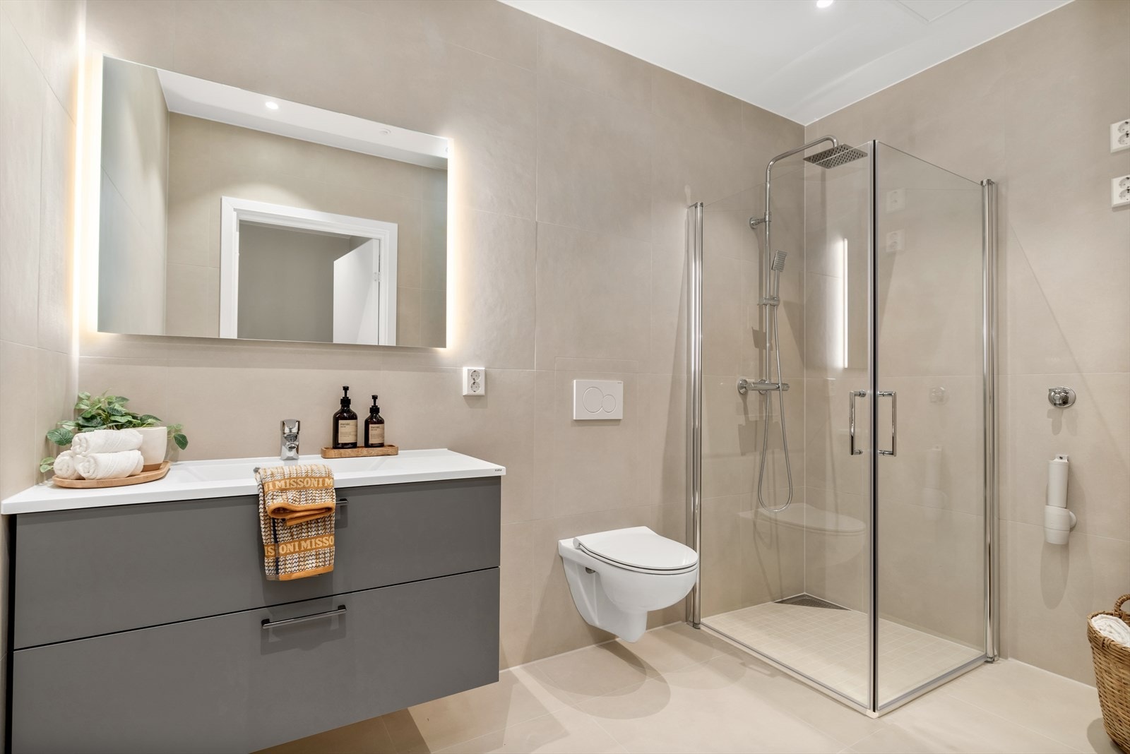 Innbydende bad som er innredet med moderne baderomsinnredning fra HTH, dusjnisje og vegghengt toalett Galleribilde