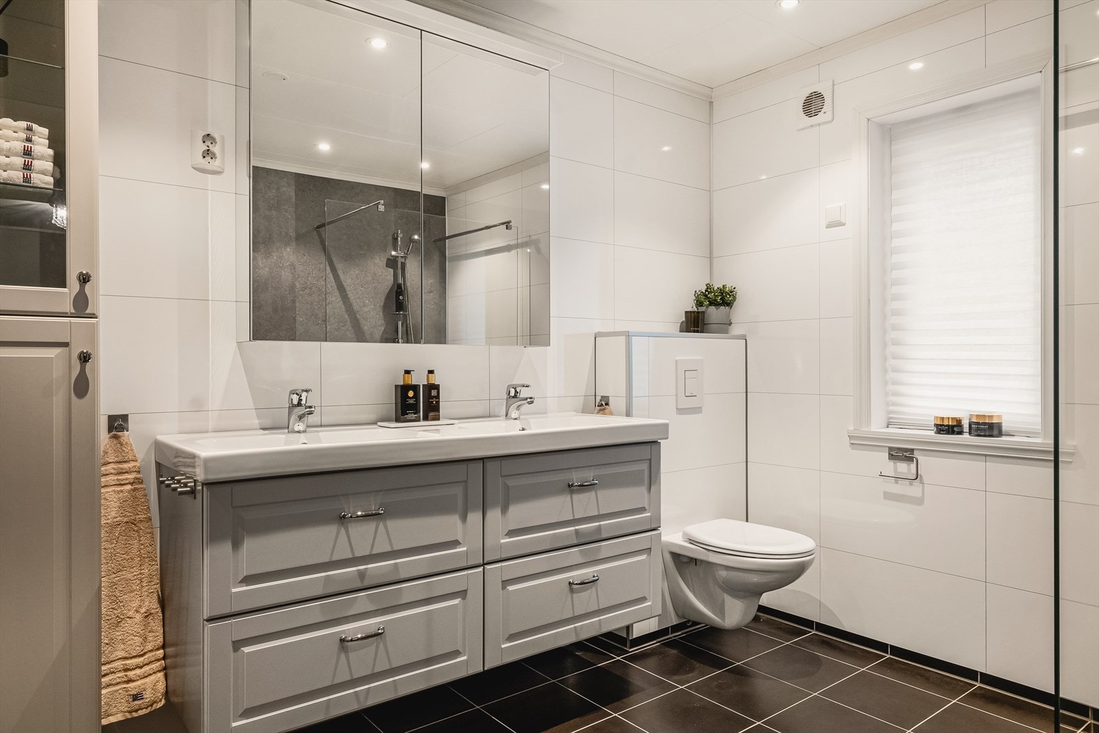 Badet i 2.etasje inneholder vegghengt toalett, dobbel helstøpt servant og skuffer under servant med profilerte fronter og dusjvegg i klart glass Galleribilde