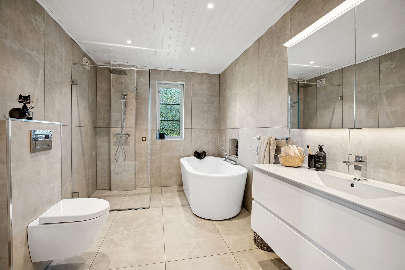 Lekkert og moderne baderom fra 2017 av god størrelse. Badet har pene fliser og gulvvarme. Innredning med servant med underskap og speilskap, dusjhjørne med regnfallsdusj og glassdører i herdet glass, frittstående badekar, samt toalett. Galleribilde