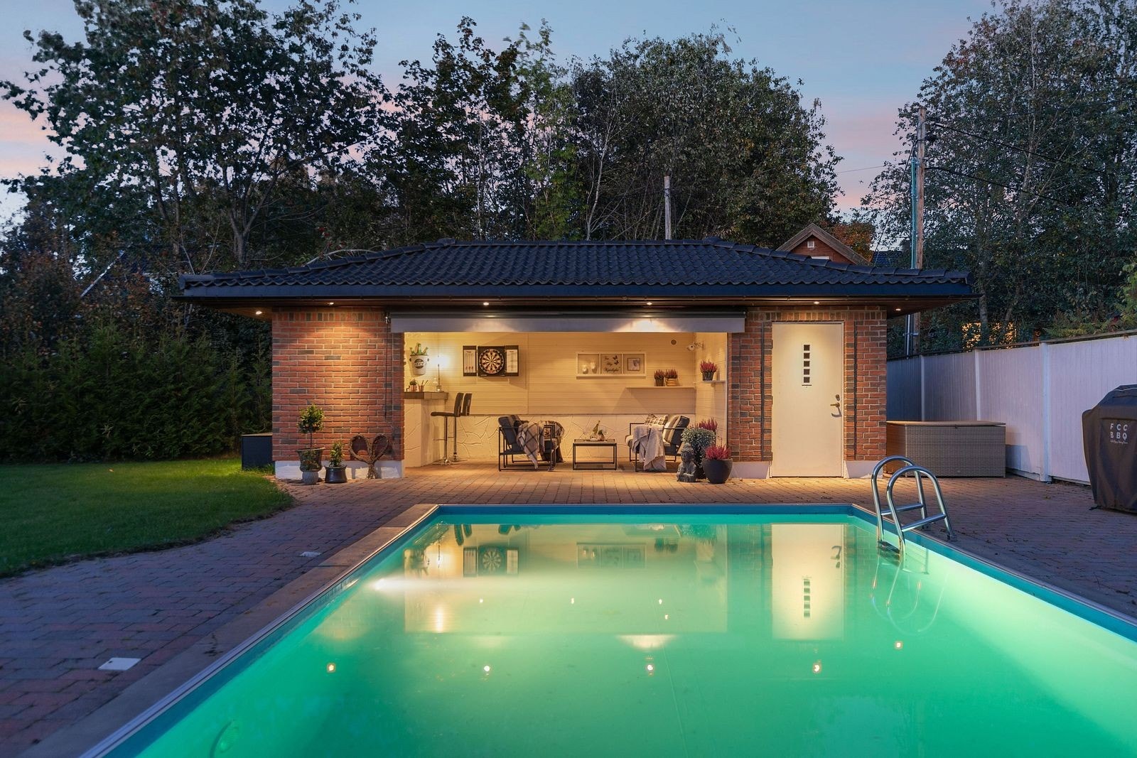 Eiendommen har praktfulle og pent opparbeidede uteområder med basseng, gressplen og en romslig hagestue. Galleribilde